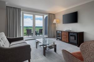 约克Delta Hotels by Marriott York的客厅配有电视、沙发和椅子