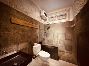 金塔马尼巴厘火山露台住宿加早餐旅馆的浴室配有卫生间、盥洗盆和浴缸。