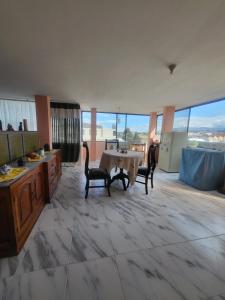 拉塔昆加Como en casa的带大窗户的客房内设有带桌椅的厨房
