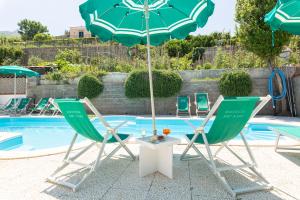 伊斯基亚蒂娜公寓别墅酒店的游泳池旁的两把椅子和一把遮阳伞