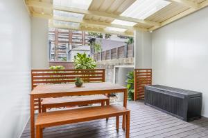 悉尼Surry Hills l 2 Bedroom Terrace Home的天井配有长凳、桌子和暖气