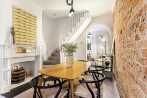 悉尼Surry Hills l 2 Bedroom Terrace Home的一间设有桌椅和砖墙的用餐室
