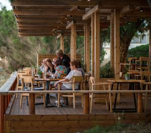 基萨莫斯阿芙罗狄蒂海滩酒店的坐在甲板上桌子上的一群人