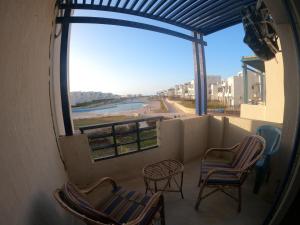 阿莱曼Remas resort的阳台配有椅子,享有河景