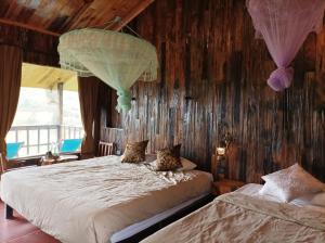 Nam San木仓柴生态旅馆 的木墙客房的两张床