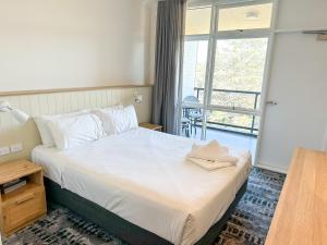 华纳海湾波音特皮皮酒店的一间卧室设有一张床和一个大窗户