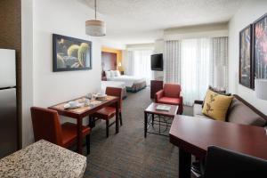 凤凰城凤凰城梅奥医学中心沙漠景观原住客栈的酒店客房设有桌子和客厅。