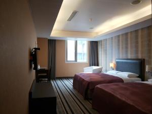 桃园市大都会旅馆 的酒店客房设有两张床和窗户。