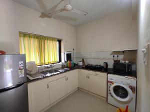科尔瓦Beach Apartment 2,COLVA , GOA, INDIA的厨房配有冰箱、洗衣机和烘干机