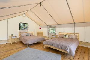 伯尼Twin Falls Luxury Glamping - Cozy Retreat的一间帐篷内带两张床的卧室