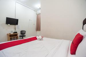 茂物RedDoorz Plus near RS PMI Bogor的一间卧室,床上有泰迪熊