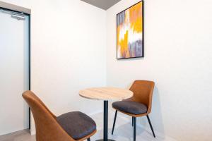 东京uGard Shimomaruko的画室里的一张桌子和两把椅子