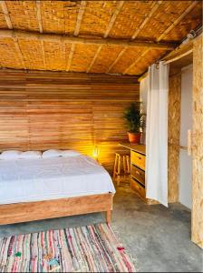 曼克拉El Mirador de Máncora的一间卧室设有一张床和木墙