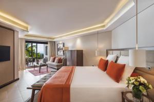 格兰贝伊Royal Palm Beachcomber Luxury的一间带大床的卧室和一间客厅