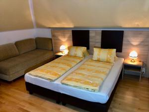 滨湖科伊查赫Landhaus Scherling的一间卧室配有一张床、一张沙发和两盏灯。
