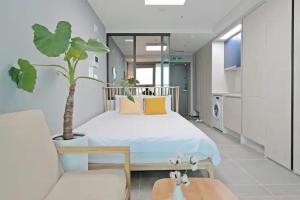 釜山Elmomento Gwangan的一间卧室配有一张大床和盆栽植物