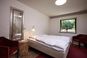 马里博Jägerhuset的一间卧室配有一张床、镜子和椅子