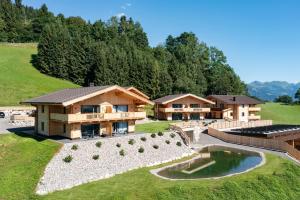 伊特尔Alpenchalets Oberlaiming的享有带池塘的房屋的空中景致