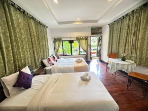 Ban Yang PlaoSoft Resort Kad Farang Hangdong的酒店客房,设有两张床和一张沙发