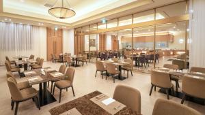 西归浦市Mercure Ambassador Jeju的一间带桌椅的用餐室和一间餐厅