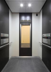 福知山福知山太阳道酒店的走廊上设有一扇门,里面装有镜子