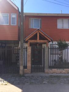 康塞普西翁HOsTAL PALMED的红色的房子,设有木门和围栏