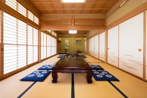 上越市-izen 高田- 柳精庵的一间设有桌子和蓝色垫子的客房