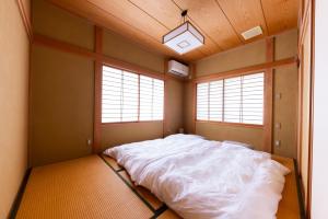 上越市-izen 高田- 柳精庵的一间卧室设有一张大床和两个窗户