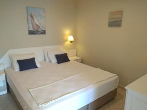 比泰兹UzHan Beach Hotel的卧室配有带蓝色枕头的大型白色床