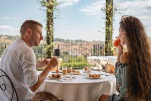 科斯蒂廖莱达斯蒂Monvì Wine Relais的坐在餐桌旁吃食物的男人和女人