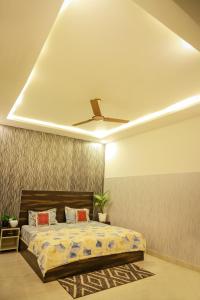 法里达巴德Aagman Stays By Kasa Lusso的一间卧室设有一张床和天花板