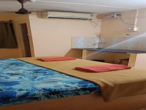 卡纳科纳Dmello Guest House的一间卧室配有一张带两个红色枕头的床