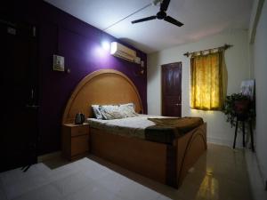 卡纳科纳Dmello Guest House的一间卧室配有一张大床和木制床头板