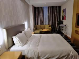 新郑郑州港区智选假日酒店的酒店客房,配有床和沙发