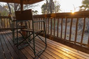 NataNata Lodge的木甲板上的椅子,享有日落美景