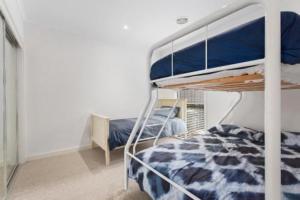 托基Golf Beach Retreat Torquay的一间卧室配有一张双层床和蓝色棉被