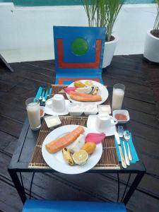 阿姆巴托洛阿卡Moemoea Lodge的餐桌,带食物、饮料和牛奶盘