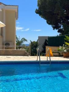 圣安东尼奥·德·卡隆Villa Costera B&B的一座房子前面的蓝色海水游泳池
