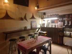 金边TaSahin Hostel & Turkish Restaurant & Bar的一间带桌子的用餐室和一间带凳子的酒吧