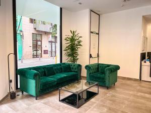 大加那利岛拉斯帕尔马斯Hotel MG Poniente的客厅配有两张绿色沙发和一张桌子