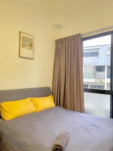 新加坡2 BR with city view near Subway in central的一间卧室配有一张带黄色枕头的床和一扇窗户