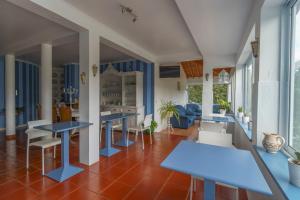 圣维森特费雷拉Quinta das Hortências的配有蓝色桌椅和窗户的客房
