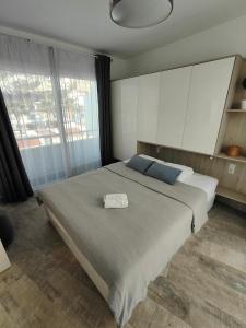 阿德耶Malibu Park Apartments Sol的一间卧室设有一张大床和一个大窗户