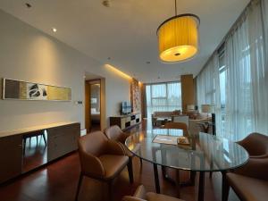 深圳深圳欢乐海岸万豪行政公寓的客厅配有玻璃桌和椅子