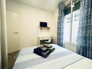 马德里Hermoso piso en Chamberi的一间卧室配有一张带椅子的床和一扇窗户