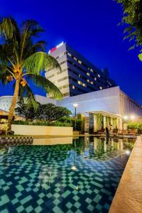 当格浪d'primahotel Tangerang的大楼前设有游泳池的酒店