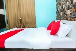 阿加尔塔拉OYO Hotel Sonar Gaon的一张带红色和白色枕头的床