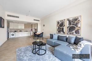 迪拜WelHome - Elegant Apartment Retreat at Widcombe House 3的客厅配有蓝色的沙发和桌子