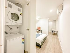 悉尼Burwood Studio的配有床和洗衣机的房间