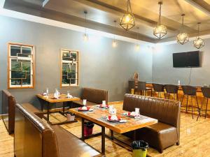 森莫诺隆Chomkatae Bungalows的餐厅设有桌椅和平面电视。